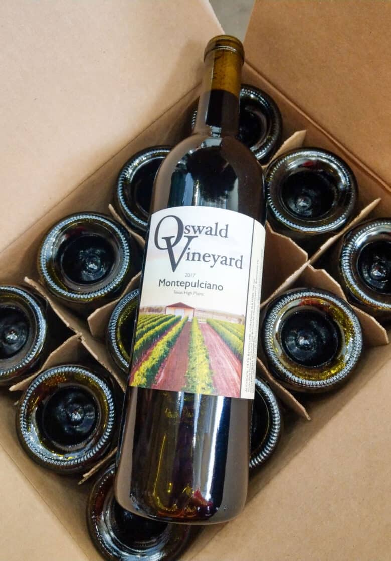 Labeling 2017 Vintage - a bottle of Montepulciano wine laying on top of an open case of wine.