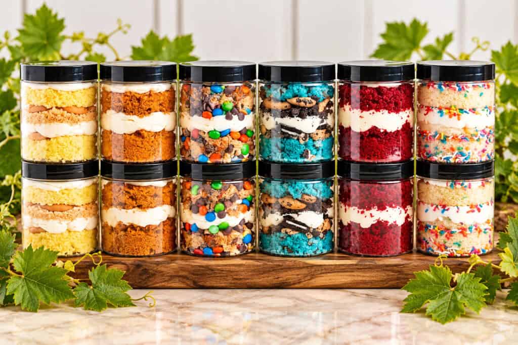 Cake Jars from The Market at Oswald Vineyard shown in different flavors stacked together on a counter.